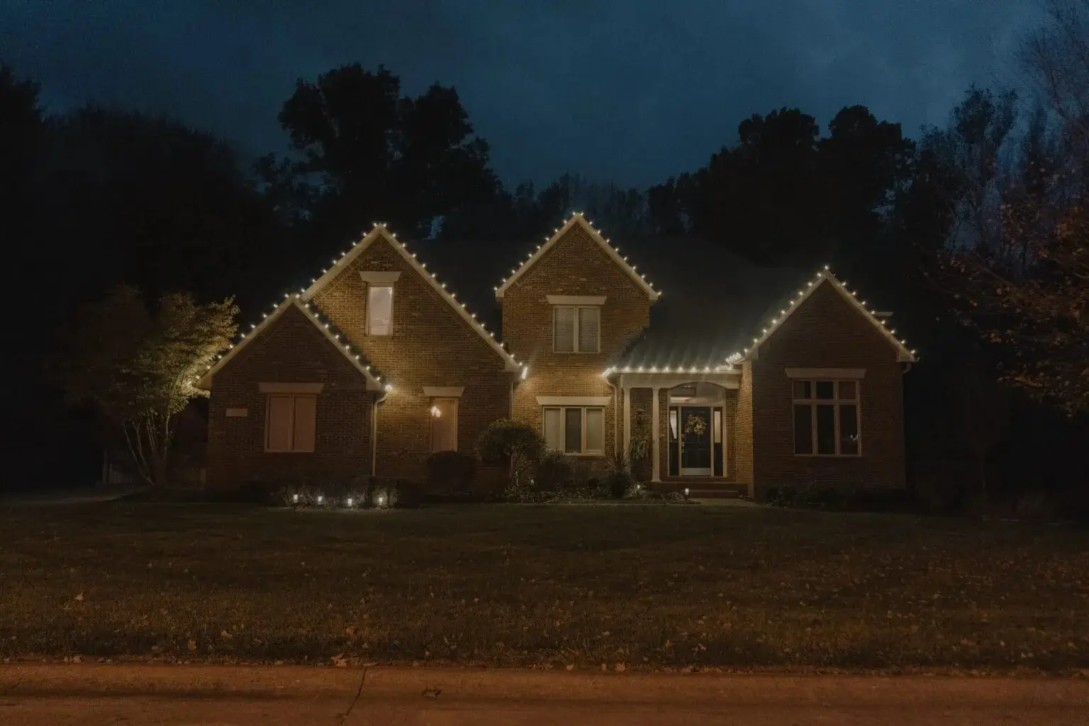 A house outlined in holiday lights at night